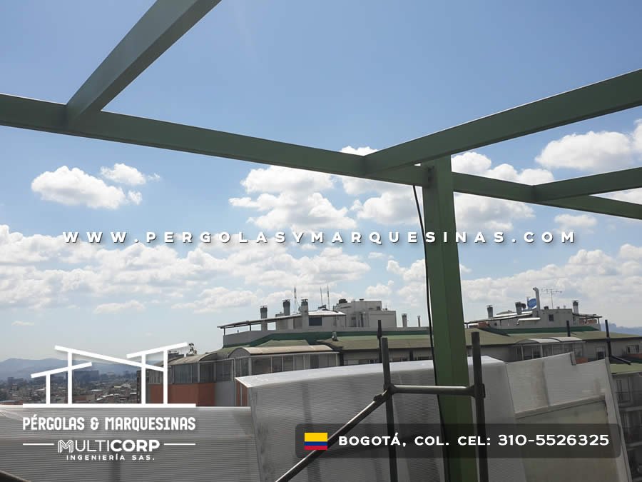 Estructura metalica verde para techo abierto en azotea con vista a edificaciones urbanas y cielo en Bogotá, Colombia. Multicorp Ingeniería SAS.