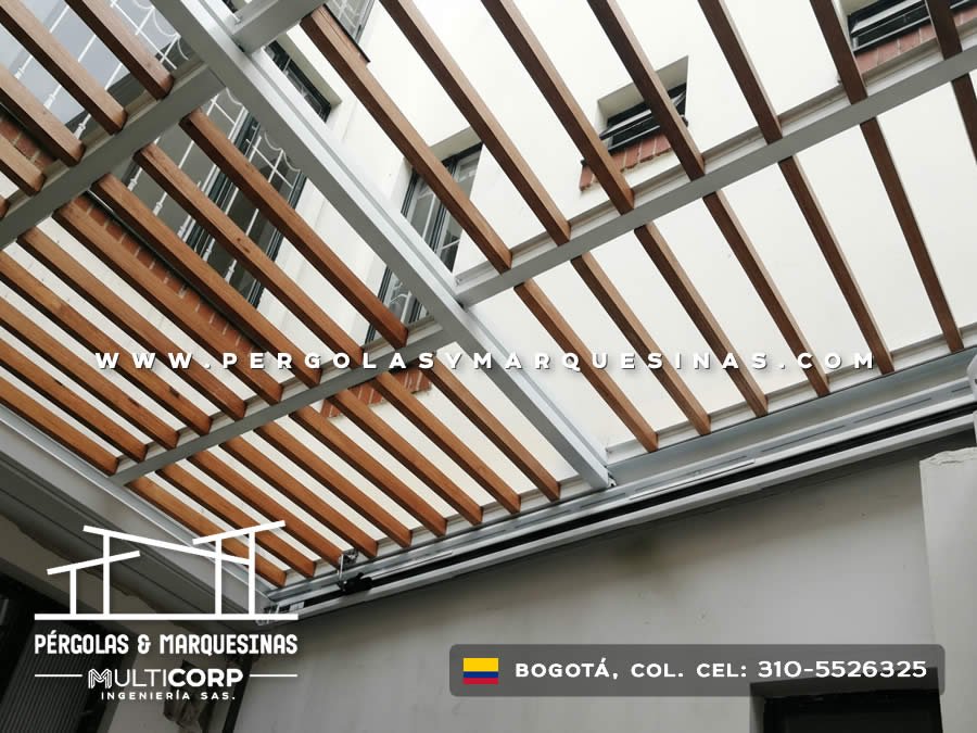 Pergola con listones de madera y estructura metalica blanca en zona entre edificios urbanos en Bogotá, Colombia. Multicorp Ingeniería SAS.