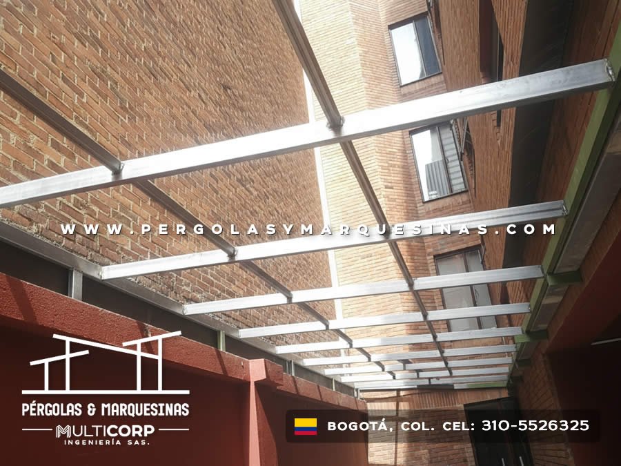 Estructura galvanizada para techo abierto en pasillo estrecho entre muros de ladrillo de edificios en Bogotá, Colombia. Multicorp Ingeniería SAS.