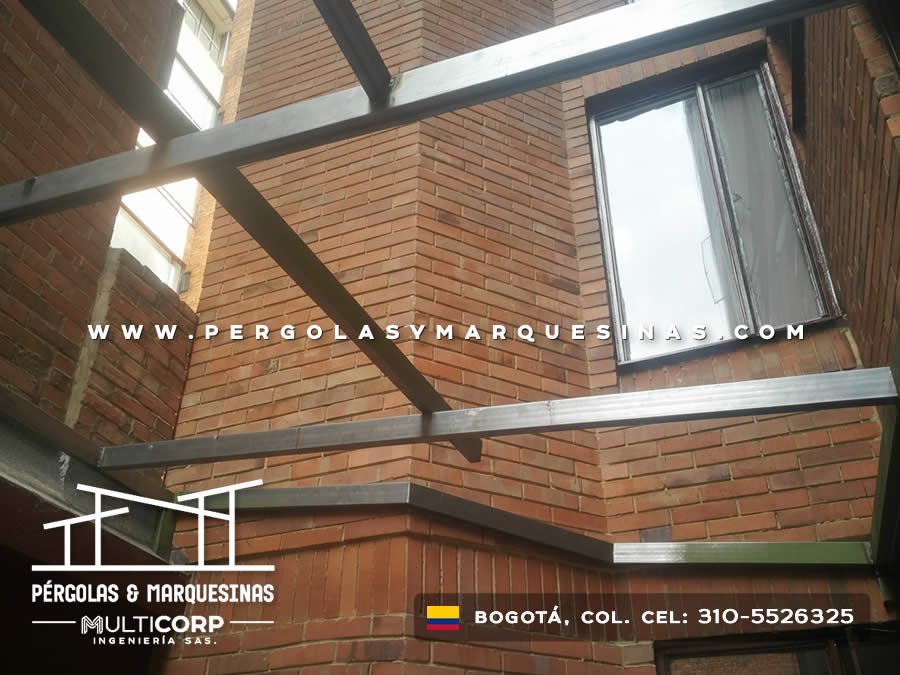 Detalle de estructura galvanizada en pasillo entre muros de ladrillo con ventana en edificio urbano en Bogotá, Colombia. Multicorp Ingeniería SAS.