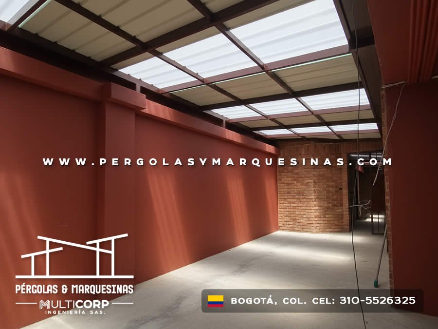 Cubierta de policarbonato con estructura metalica roja en espacio cerrado con muros rojos en Bogotá, Colombia. Multicorp Ingeniería SAS.