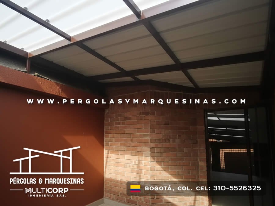 Cubierta de policarbonato con estructura metalica marron en espacio con muro de ladrillo y pared roja en Bogotá, Colombia. Multicorp Ingeniería SAS.