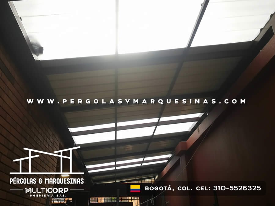 Techo de policarbonato con estructura metalica oscura en pasillo estrecho entre muros de ladrillo en Bogotá, Colombia. Multicorp Ingeniería SAS.
