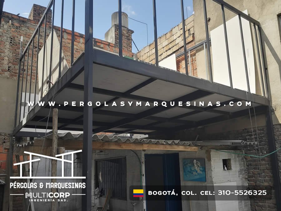 Estructura metalica gris para plataforma elevada en patio urbano entre edificios de ladrillo en Bogotá, Colombia. Multicorp Ingeniería SAS.