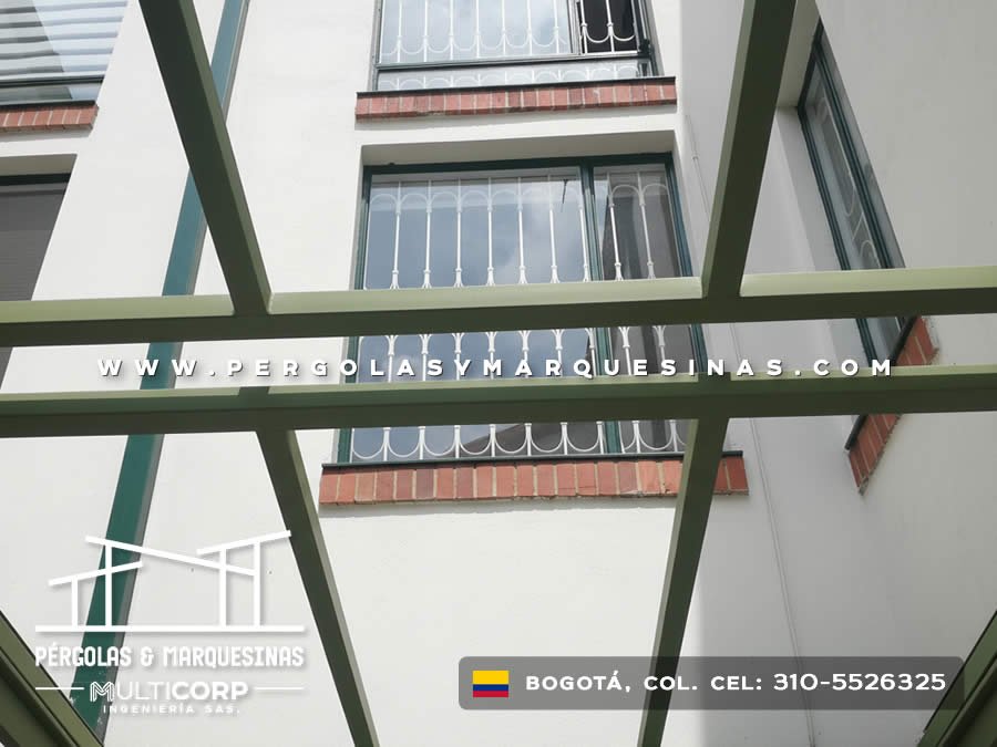 Estructura metalica verde abierta en patio interior frente a fachada de edificio con ventanas en Bogotá, Colombia. Multicorp Ingeniería SAS.