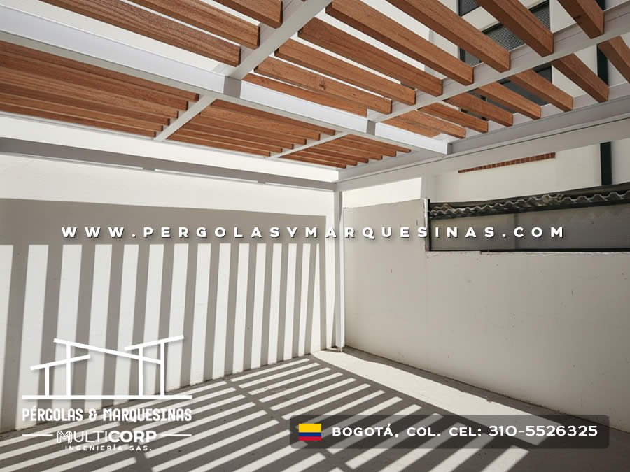 Pergola con listones de madera y estructura blanca con pasamanos vertical en terraza residencial en Bogotá, Colombia. Multicorp Ingeniería SAS.