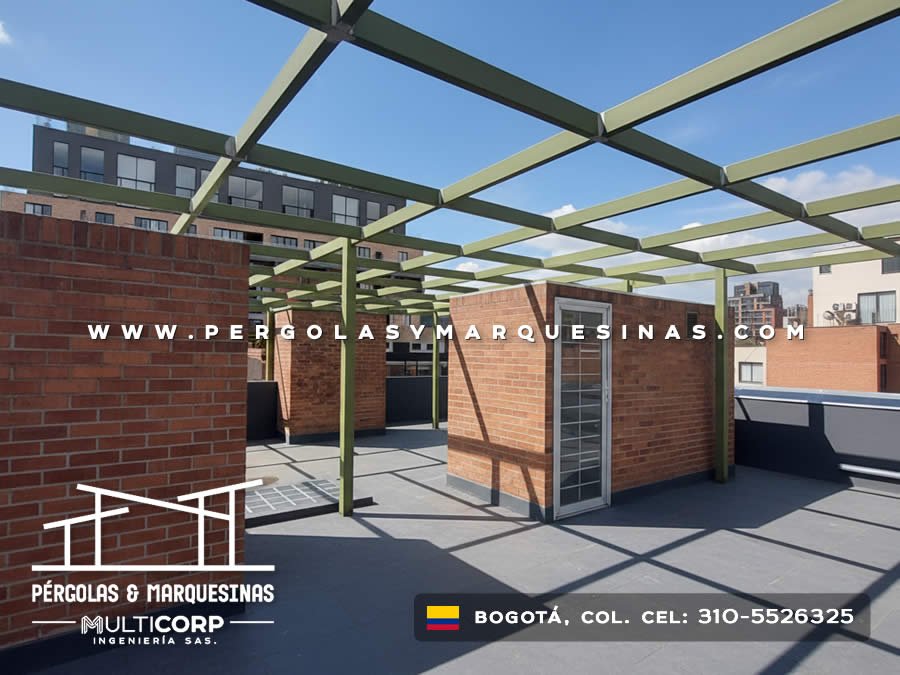 Pergola con estructura metalica verde abierta en azotea moderna con modulo de ladrillo y edificios urbanos en Bogotá, Colombia. Multicorp Ingeniería SAS.
