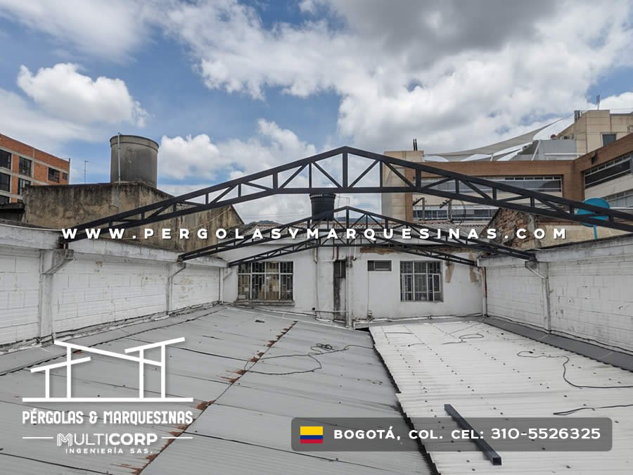 Estructura metalica negra con tirantes triangulares en azotea comercial con edificios urbanos al fondo en Bogotá, Colombia. Multicorp Ingeniería SAS.