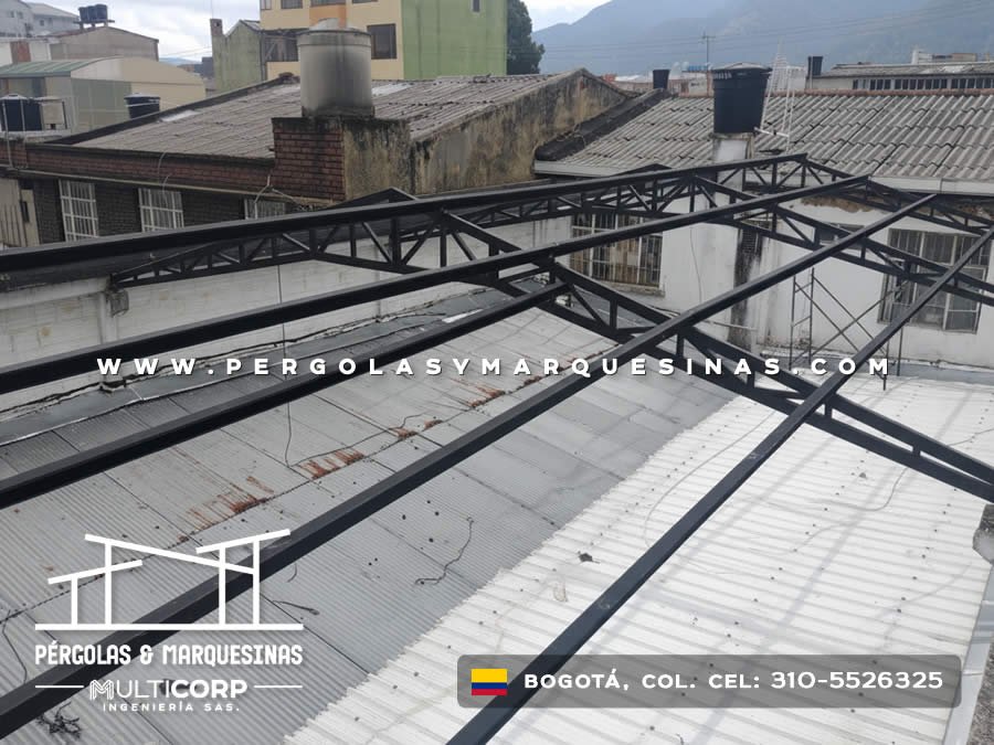 Estructura metalica negra con tirantes triangulares en azotea con casas tradicionales y montanas en Bogotá, Colombia. Multicorp Ingeniería SAS.