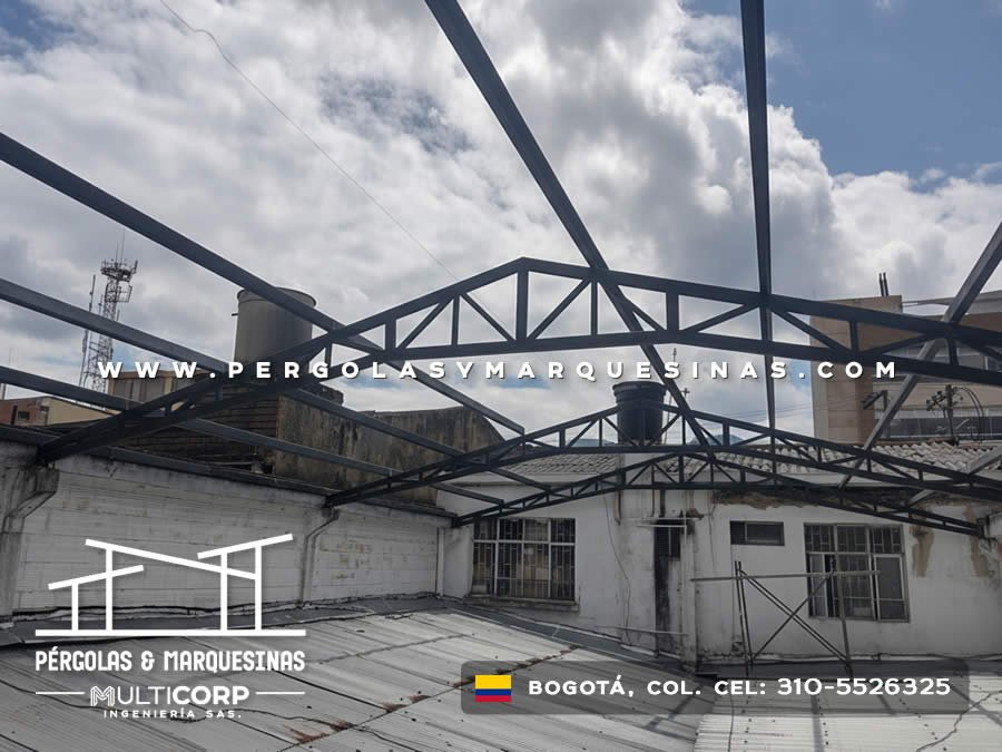 Estructura metalica negra con tirantes triangulares en azotea comercial con vista a edificios y antenas en Bogotá, Colombia. Multicorp Ingeniería SAS.