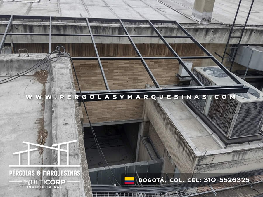Estructura metalica oscura para techo en azotea comercial con muro de piedra y equipos de aire acondicionado en Bogotá, Colombia. Multicorp Ingeniería SAS.