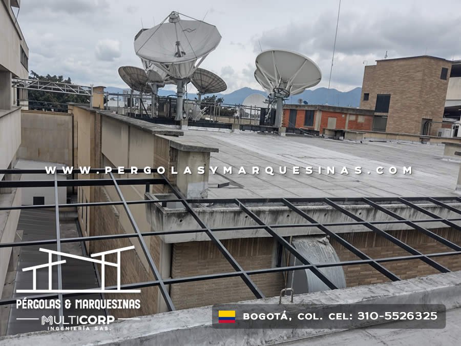 Estructura metalica negra en azotea comercial con antenas satelite grandes y vista a montanas en Bogotá, Colombia. Multicorp Ingeniería SAS.