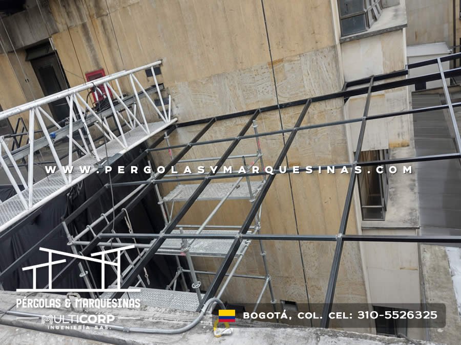 Estructura metalica negra en proceso de instalacion con andamios en fachada de edificio comercial en Bogotá, Colombia. Multicorp Ingeniería SAS.