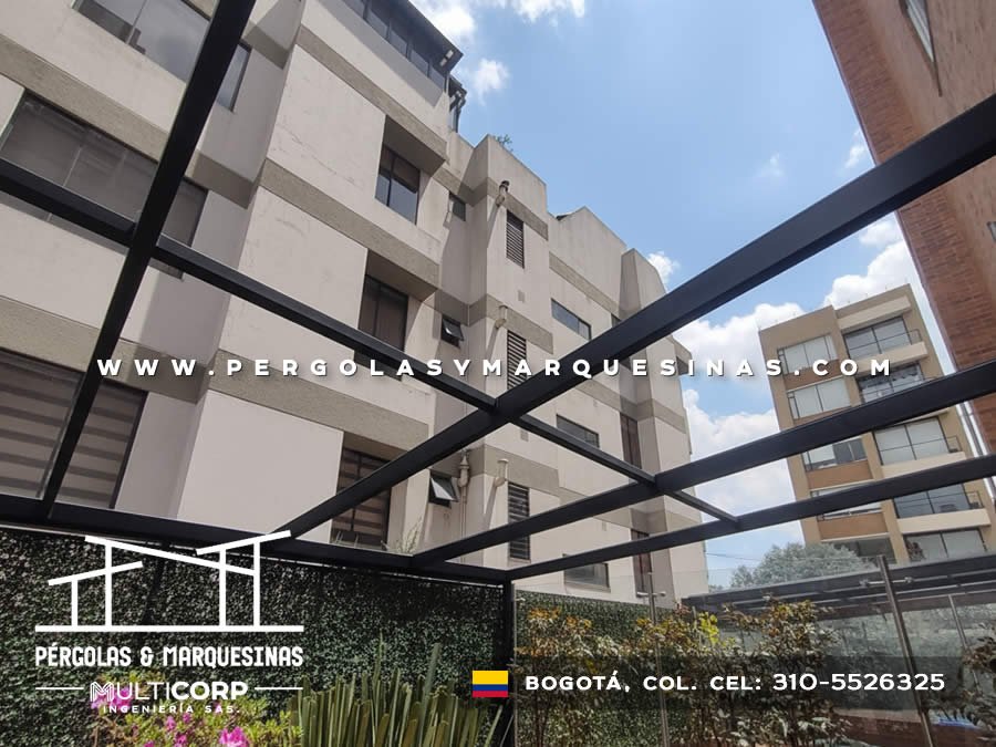 Estructura metalica negra abierta en terraza con jardin vertical frente a fachada de edificio alto en Bogotá, Colombia. Multicorp Ingeniería SAS.