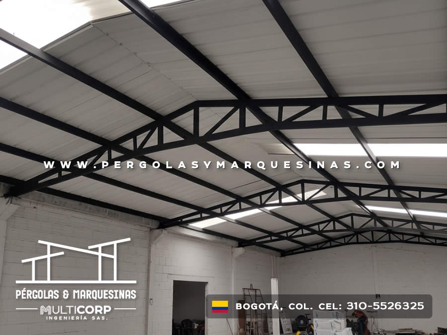 Techo industrial con estructura negra tirantes y claraboyas en nave con elementos de trabajo en Bogotá, Colombia. Multicorp Ingeniería SAS.