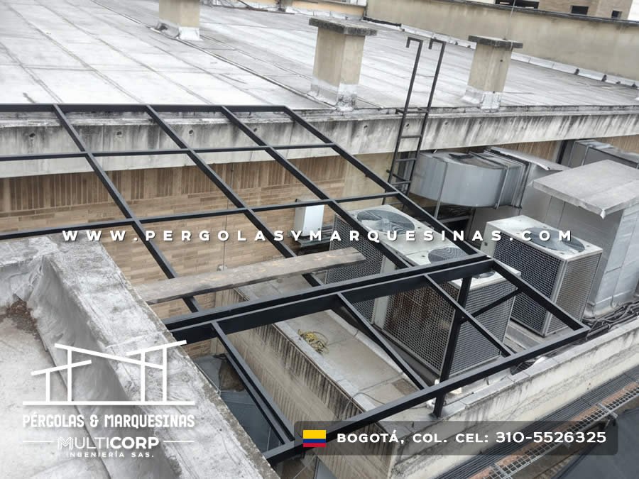 Estructura metalica oscura en azotea comercial con muros de piedra y equipos de climatizacion en Bogotá, Colombia. Multicorp Ingeniería SAS.