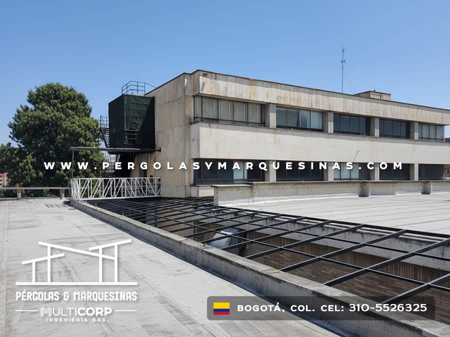 Cubierta metalica oscura sobre azotea institucional edificio concreto cielo despejado en Bogotá, Colombia. Multicorp Ingeniería SAS.