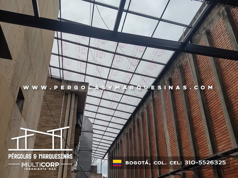 Cubierta translucida estructura metalica negra pasillo alto muros ladrillo concreto edificio en Bogotá, Colombia. Multicorp Ingeniería SAS.