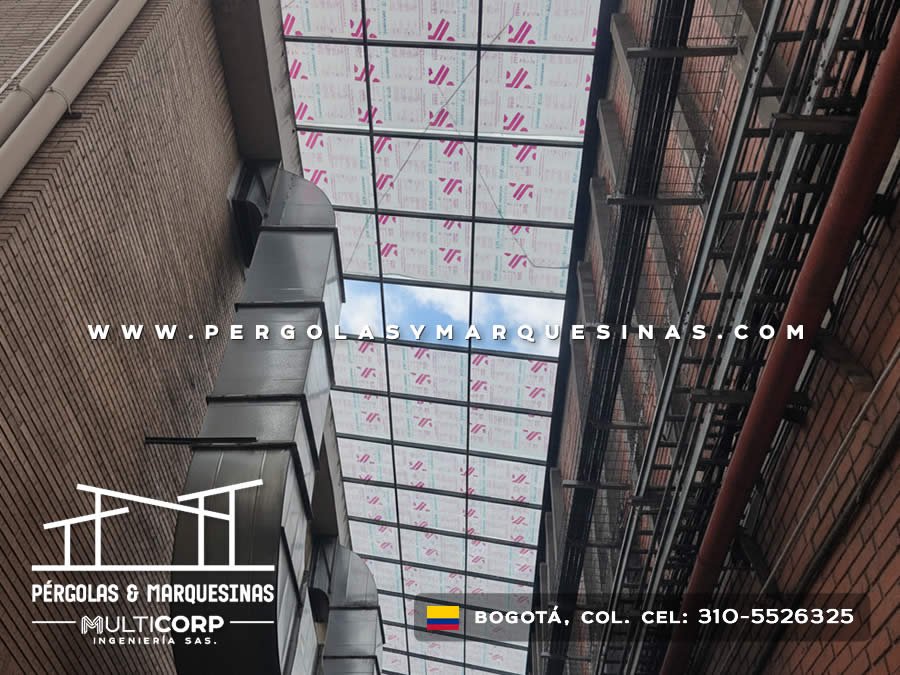 Cubierta translucida metalica oscura pasillo alto muros ladrillo conductos ventanas edificio en Bogotá, Colombia. Multicorp Ingeniería SAS.