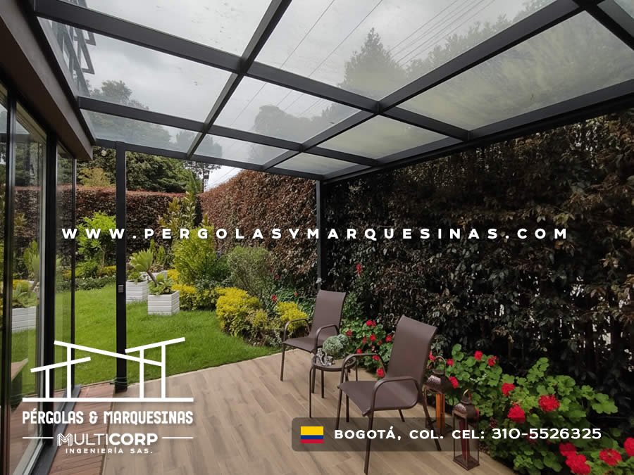 Cubierta metalica negra vidrio templado iluminacion terraza piso madera jardin cesped flores en Bogotá, Colombia. Multicorp Ingeniería SAS.
