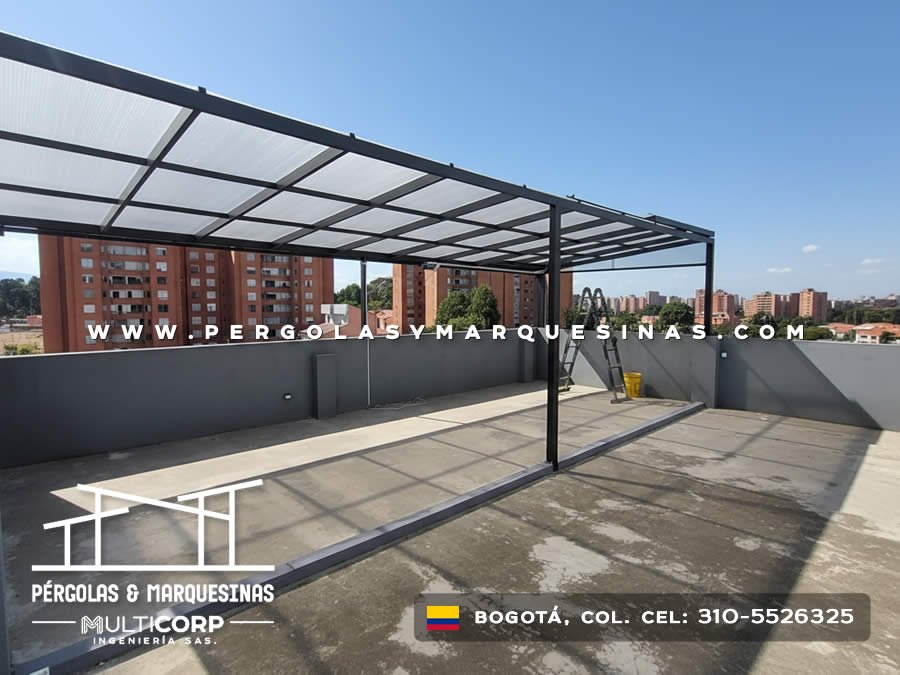 Estructura metalica negra policarbonato azotea residencial muros grises edificios urbanos cielo despejado en Bogotá, Colombia. Multicorp Ingeniería SAS.