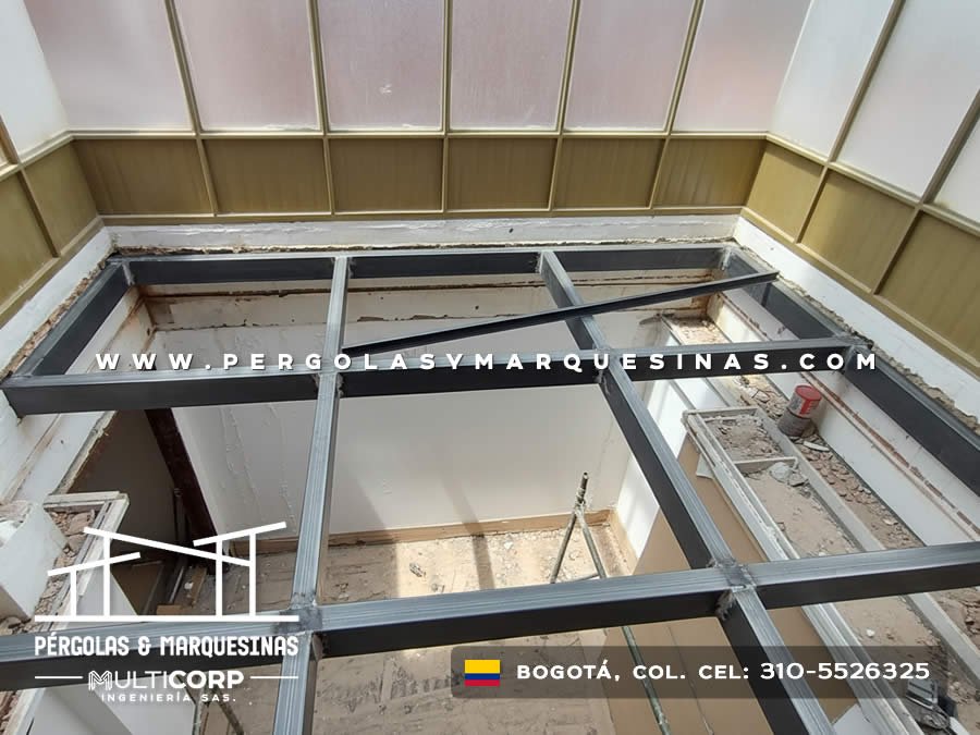 Estructura metalica oscura claraboya interior construccion muros blancos ladrillo obra en Bogotá, Colombia. Multicorp Ingeniería SAS.