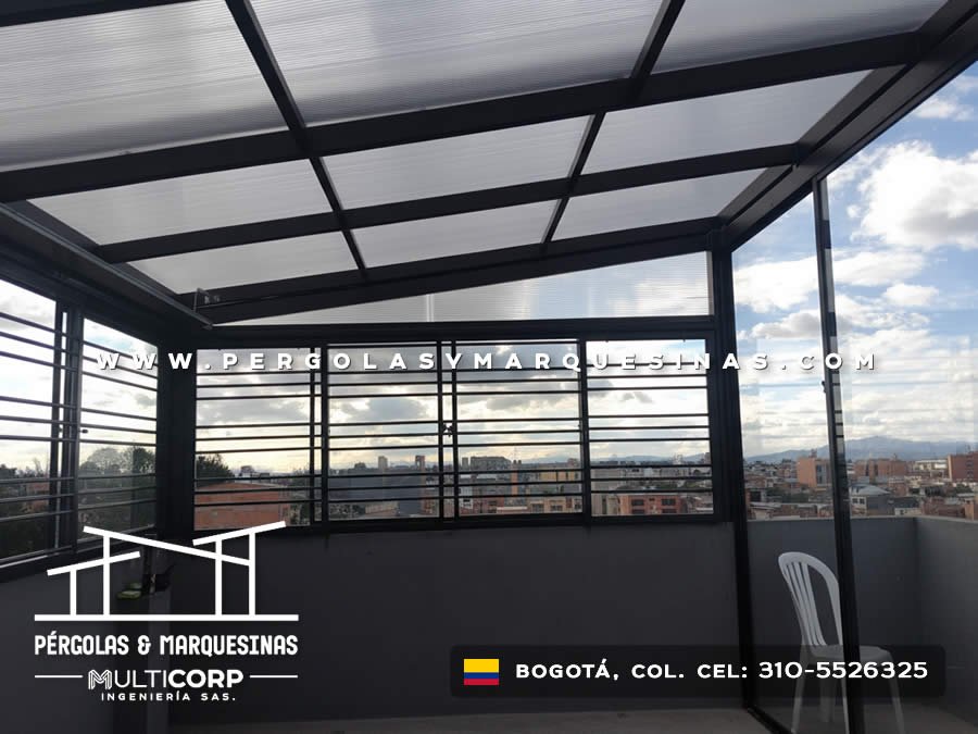 Cubierta metalica negra policarbonato terraza cerrada barandas horizontales edificios montanas cielo nublado en Bogotá, Colombia. Multicorp Ingeniería SAS.