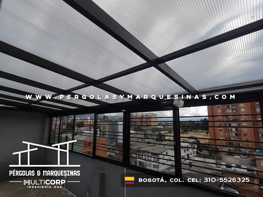 Cubierta metalica negra policarbonato interior ventanas panoramicas barandas edificios montanas cielo nublado en Bogotá, Colombia. Multicorp Ingeniería SAS.
