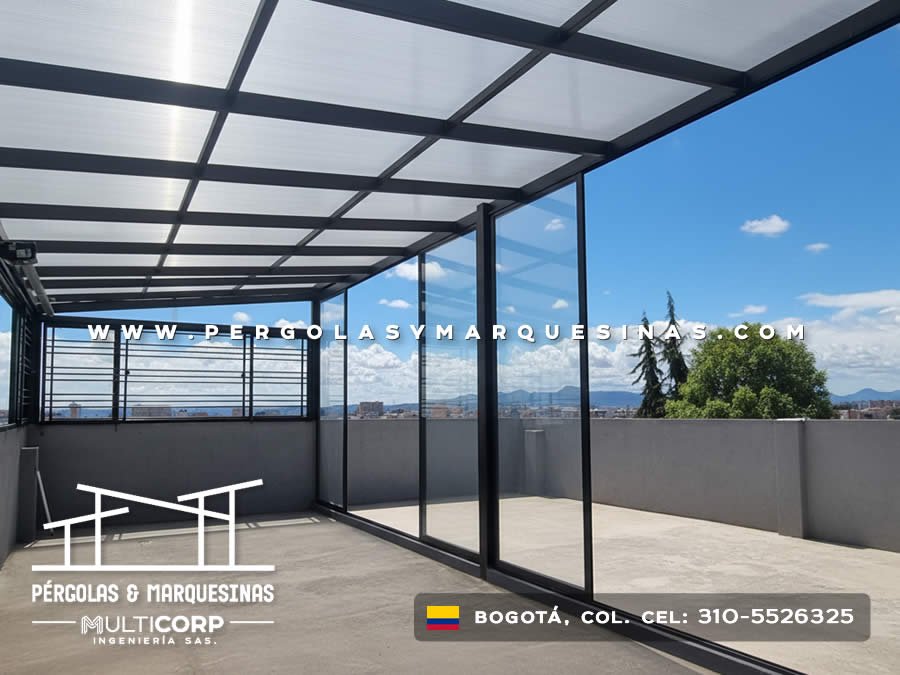 Cubierta metalica negra policarbonato terraza cerrada divisiones vidrio muros grises cielo azul montanas en Bogotá, Colombia. Multicorp Ingeniería SAS.