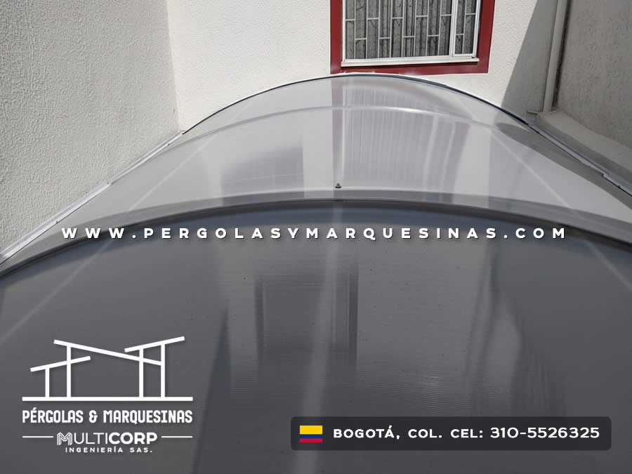Techo curvo policarbonato translucido estructura metalica patio interior ventana roja muros blancos en Bogotá, Colombia. Multicorp Ingeniería SAS.