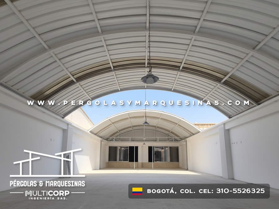 Techo curvo policarbonato estructura metálica blanca patio interior lámpara muros blancos en Bogotá, Colombia. Multicorp Ingeniería SAS.