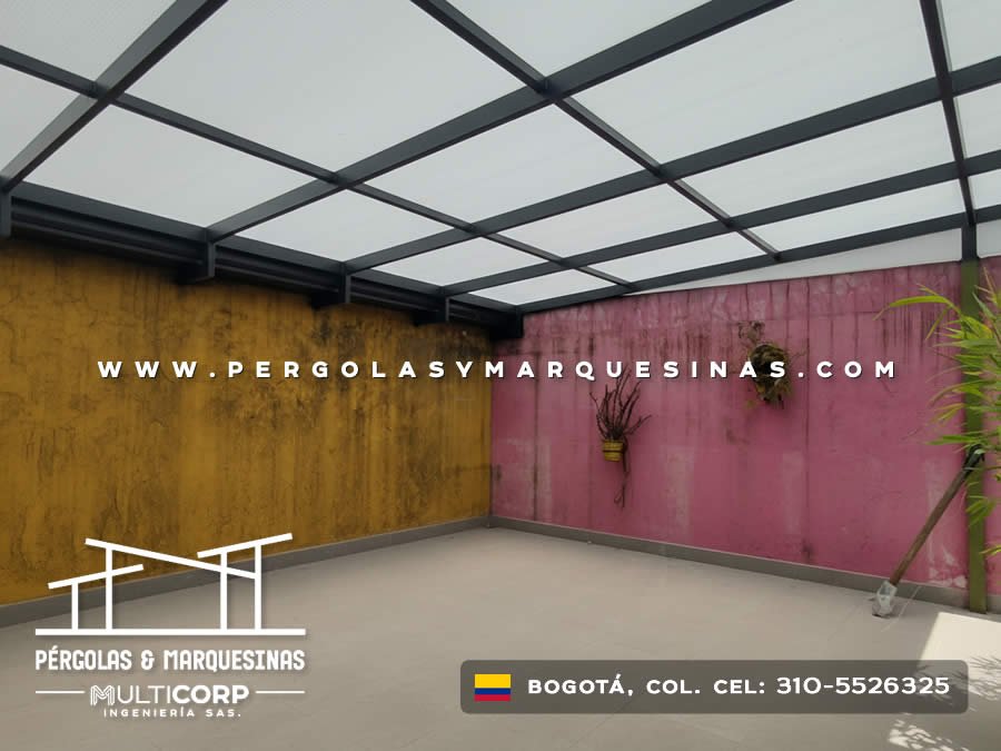 Cubierta policarbonato estructura metálica gris patio muros colores vegetación decorativa en Bogotá, Colombia. Multicorp Ingeniería SAS.