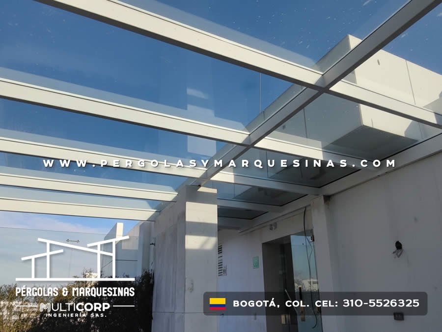 Pérgola vidrio templado estructura metálica blanca terraza muros blancos puerta vidrio en Bogotá, Colombia. Multicorp Ingeniería SAS.