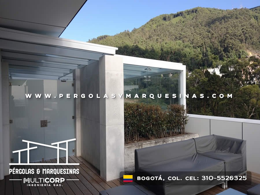 Pérgola vidrio templado estructura blanca terraza jardinera arbustos mobiliario exterior jardín en Bogotá, Colombia. Multicorp Ingeniería SAS.