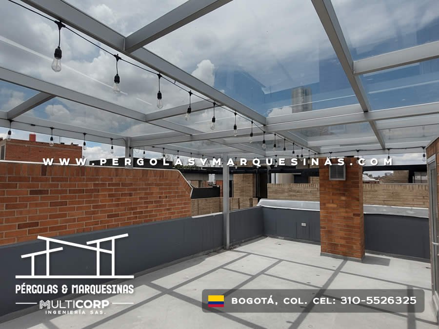 Techo de vidrio templado con estructura metalica y luces en terraza amplia de edificio urbano en Bogotá, Colombia. Multicorp Ingeniería SAS.