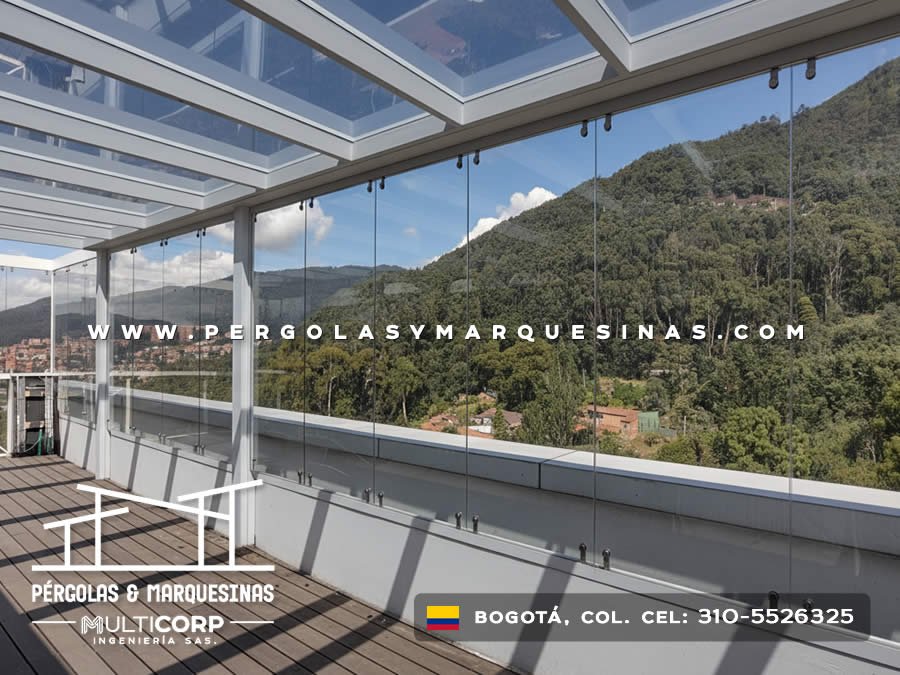 Cubierta de vidrio templado con estructura metalica blanca y deck de madera en terraza con vista a montes en Bogotá, Colombia. Multicorp Ingeniería SAS.