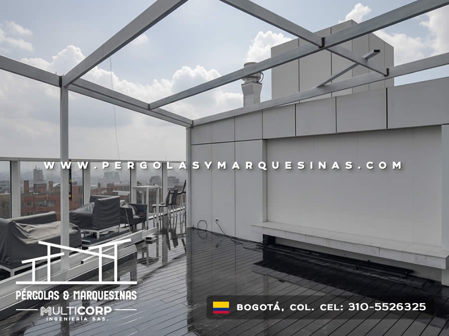 Cubierta con estructura metalica blanca y deck en terraza urbana con vista a edificios en Bogotá, Colombia. Multicorp Ingeniería SAS.