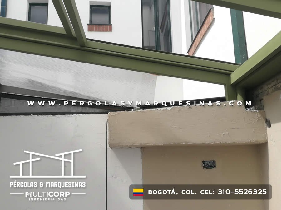 Detalle de estructura metalica verde con policarbonato adosada a muro en zona residencial de Bogotá, Colombia. Multicorp Ingeniería SAS.