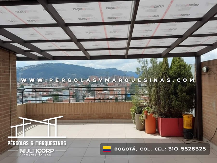 Pergola con estructura negra y policarbonato en terraza urbana con jardineras y vista a montanas en Bogotá, Colombia. Multicorp Ingeniería SAS.