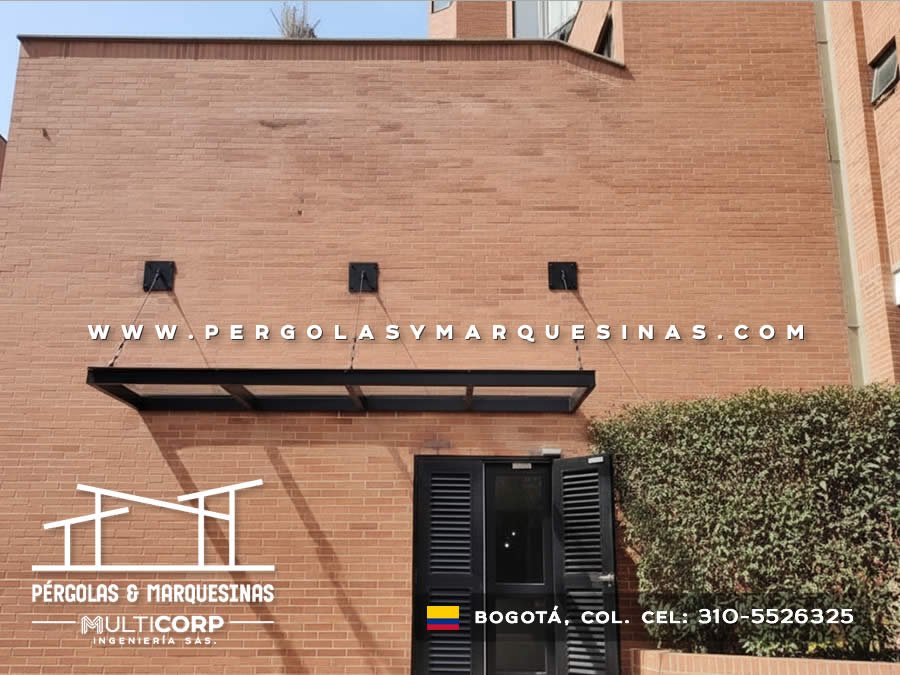 Marquesina metalica negra suspendida por cables sobre entrada de edificio en Bogotá, Colombia. Multicorp Ingeniería SAS.