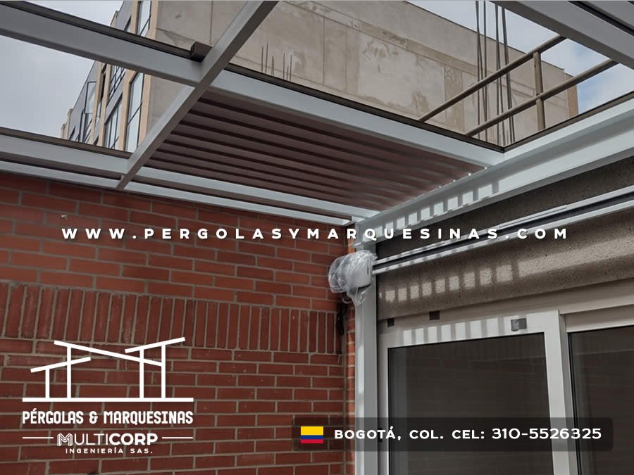 Marquesina con techo de madera estructura metálica gris y muro de ladrillo en zona de acceso residencial en Bogotá, Colombia. Multicorp Ingeniería SAS.