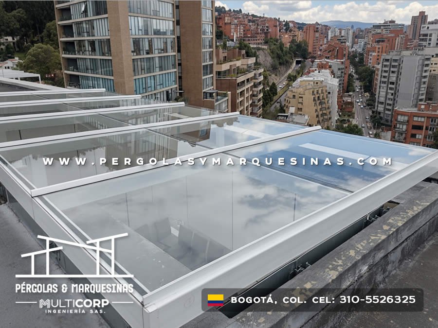 Cubierta modular de vidrio con perfiles blancos sobre terraza de edificio residencial urbano en Bogotá, Colombia. Multicorp Ingeniería SAS.
