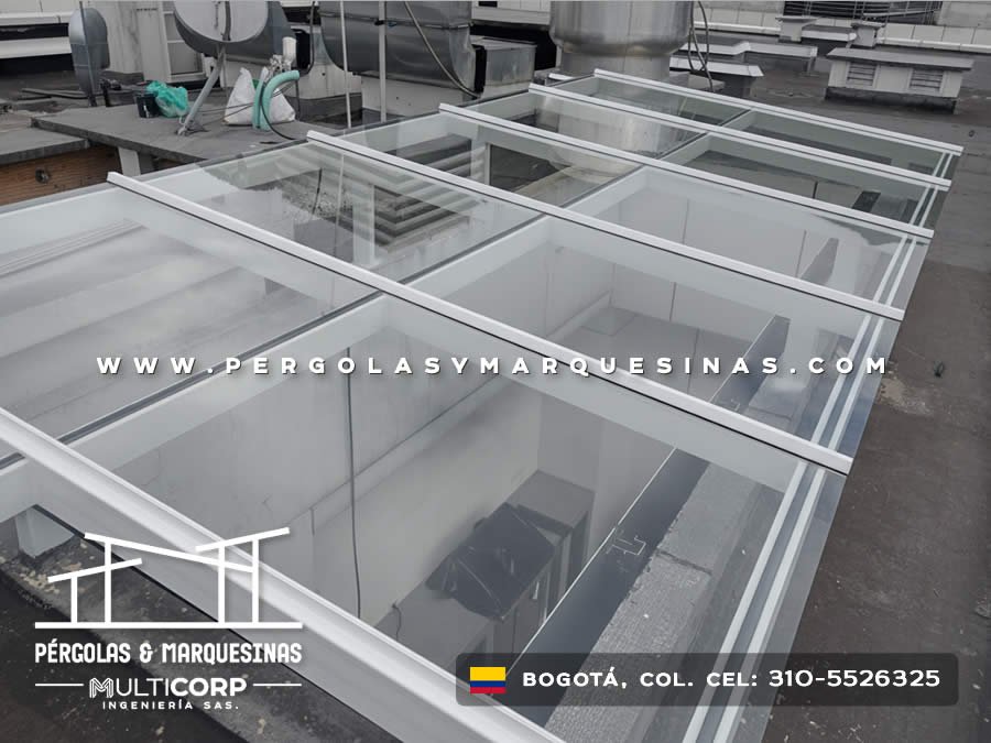 Estructura modular de vidrio con perfiles blancos en proceso de instalación sobre terraza comercial en Bogotá, Colombia. Multicorp Ingeniería SAS.