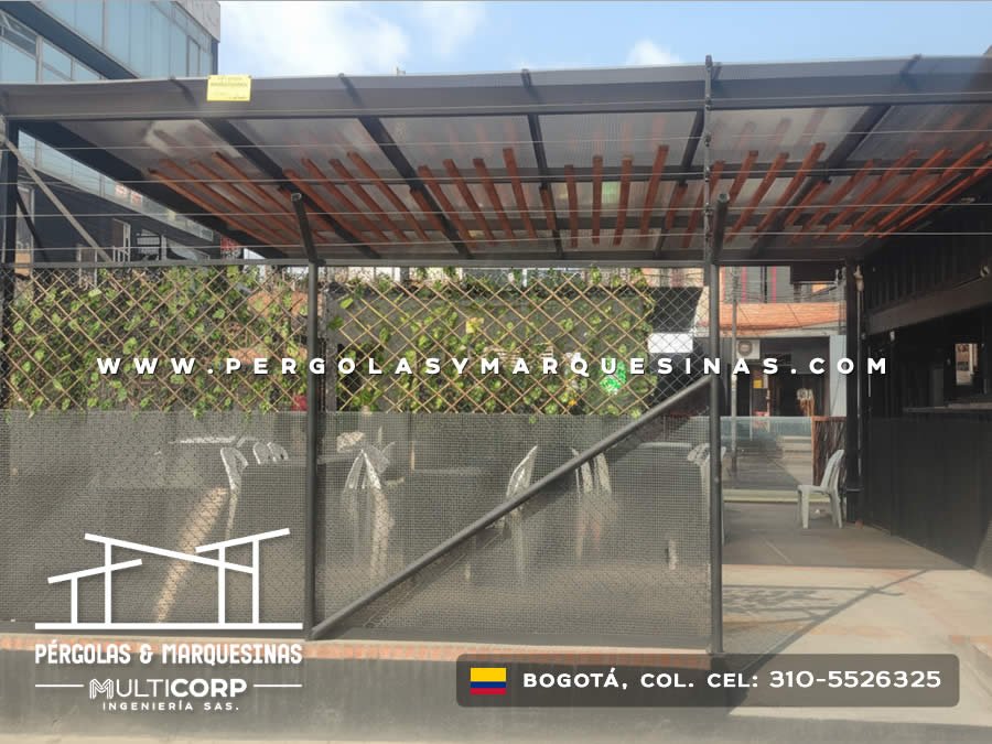 Marquesina con techo de listones de madera estructura metálica negra y malla lateral en zona recreativa en Bogotá, Colombia. Multicorp Ingeniería SAS.