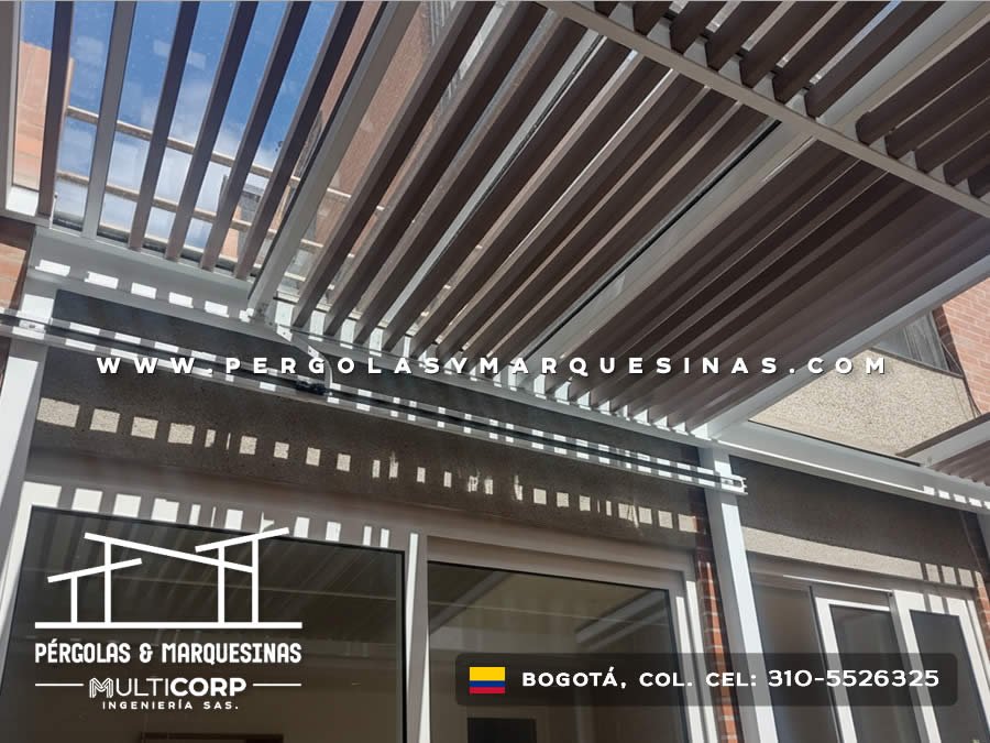 Pérgola con techo de lamas de madera oscuras estructura metálica y ventanas de vidrio en terraza residencial en Bogotá, Colombia. Multicorp Ingeniería SAS.