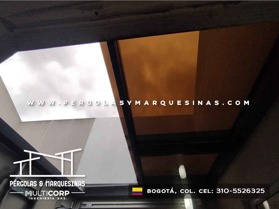 Claraboya con paneles de policarbonato bronce y perfiles negros en techo interior residencial en Bogotá, Colombia. Multicorp Ingeniería SAS.