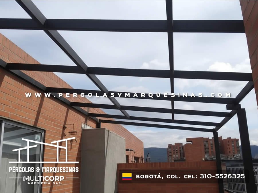 Pergola con vigas metalicas grises y jardineras con plantas sobre terraza con vista urbana en Bogotá, Colombia. Multicorp Ingeniería SAS.