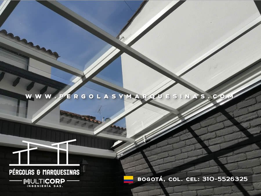 Techo retráctil con paneles de policarbonato blanco y estructura metálica sobre patio interior en Bogotá, Colombia. Multicorp Ingeniería SAS.
