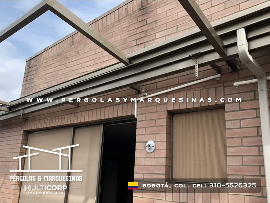Marquesina metalica con canaletas de drenaje sobre muro de ladrillo en fachada residencial en Bogotá, Colombia. Multicorp Ingeniería SAS.