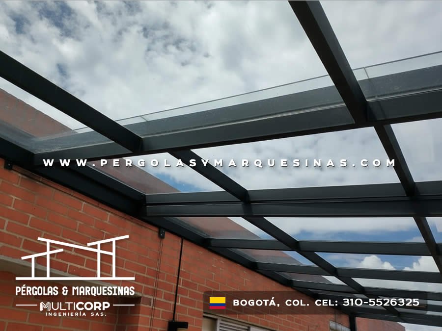 Pergola con techo de vidrio ahumado estructura metalica negra y muro de ladrillo en terraza en Bogotá, Colombia. Multicorp Ingeniería SAS.
